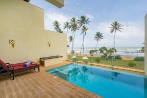 a pool with a view of the beach and the ocean at Grand Beach in Wadduwa