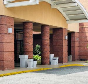 a brick building with white pots in front of it at Lynchburg Grand Essential by IHG in Lynchburg +1 photo