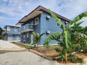 a blue house with a palm tree in front of it at Homestay Warisan Iman in Klang