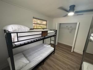 CG Miami House في ميامي: غرفة بها سريرين بطابقين ومروحة سقف