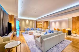 a living room with couches and a tv at Crowne Plaza Phnom Penh by IHG in Phnom Penh