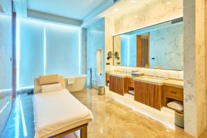 a bathroom with two sinks and a large mirror at Crowne Plaza Phnom Penh by IHG in Phnom Penh +227 photos