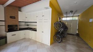a kitchen with a bike hanging on the wall at Suites Novas in Cabo Frio