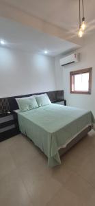 a bedroom with a large bed in a room at Suites Novas in Cabo Frio