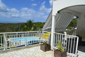 a balcony of a house with a swimming pool at La Nicotoria HAUT DE VILLA T4 in Deshaies