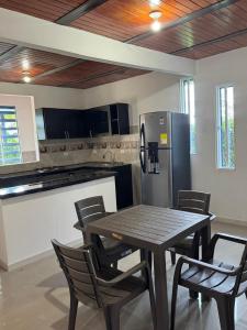 Una cocina con mesa y sillas y un refrigerador. en Cambulos 3, en Acacías