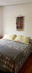 una camera da letto con un letto con cuscini e un cartello sul muro di Cabaña lago tranquilo, camino valle exploradores a Puerto Tranquilo