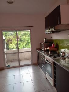 una cocina con estufa horno superior al lado de una ventana en Posada La Alemana, en Puerto Iguazú