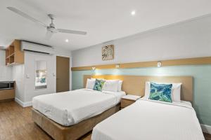 Broome Time Resort في بروم: غرفة نوم بسريرين ومطبخ +64 صورة