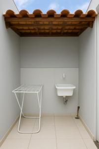 a bathroom with a sink and a table at Compras no Paraguai e pesca no Rio Paraná! in Guaíra