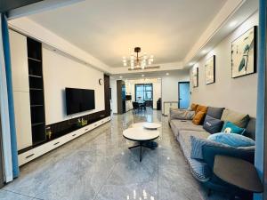 a living room with a couch and a tv at Xiaowo SmileNest Downtown Scenic Spot Ticket Service Close to Tianmen Mountain Scenic Area Ideal for Couples, Families and Group Bookings in Zhangjiajie