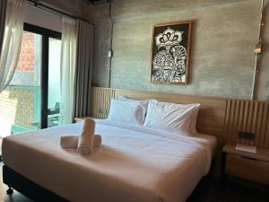 Una cama blanca con un animal de peluche encima. en Sena Hotel Langkawi, en Kampung Padang Masirat 22 fotos más