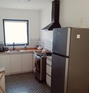 a kitchen with a refrigerator and a sink and a window at La Pausa Container House in Manantiales +4 photos