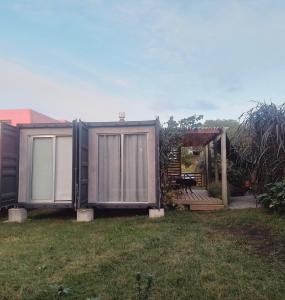 a house that is sitting in the grass at La Pausa Container House in Manantiales