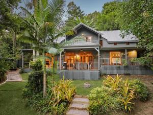 uma casa com uma palmeira na frente em Magnolia Cottage em Cooroy