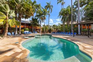 Broome Time Resort في بروم: وجود مسبح مع الكراسي والنخيل في المنتجع