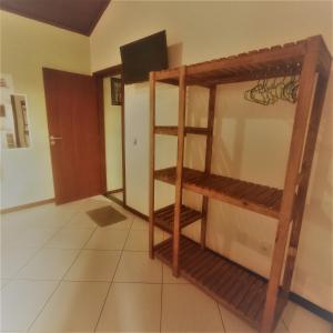 a room with a wooden shelf in a room at Bora Bora Geribá Kitnet in Búzios