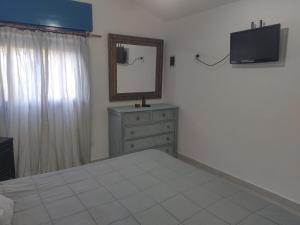 a bedroom with a bed and a mirror and a dresser at La Calma in Los Reartes