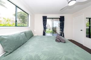 a bedroom with a green bed with a large window at Cascade View - 4 Bedroom House in Cascade