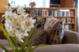a vase of white flowers sitting on a couch at Cascade View - 4 Bedroom House in Cascade