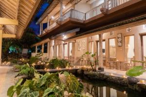 Un patio de un edificio con estanque y plantas. en Uma Shanty Homestay, en Karangasem