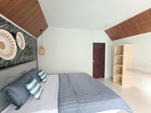 a bedroom with a large bed with blue pillows at GHangga Amed in Karangasem