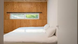 een wit bed in een kamer met een raam bij Gapyeong Santa Maria Dog-friendly Privat in Gapyeong