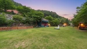 a large grassy yard with a building in the background at Gapyeong Santa Maria Dog-friendly Privat in Gapyeong