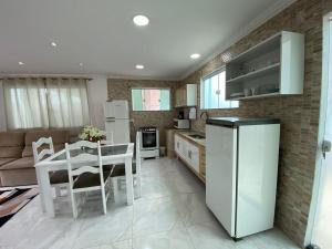 a kitchen and dining room with a table and a refrigerator at Casa independente em tuncuns in Búzios