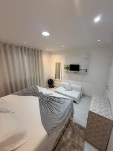 a bedroom with two beds and a couch at Casa independente em tuncuns in Búzios