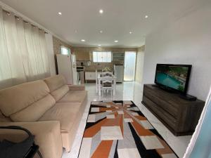 a living room with a couch and a flat screen tv at Casa independente em tuncuns in Búzios