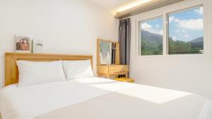 a white bed in a bedroom with a window at Gapyeong Orion PoolVilla pension in Gapyeong