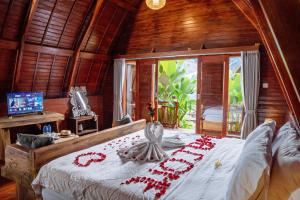a bedroom with a bed with red decorations on it at The Caldera Villas in Kubupenlokan