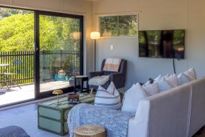 een woonkamer met een bank en een stoel bij Moana Beach House - Absolute beachfront in Onetangi in Waiheke Island