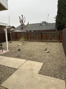 a backyard with a wooden fence and a patio at Casa Cortez C in Visalia
