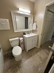 a bathroom with a toilet and a sink and a mirror at Casa Cortez C in Visalia