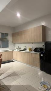 a kitchen with wooden cabinets and a black refrigerator at 9 Beradik Homestay in Kajang