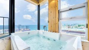 een bad met uitzicht op de oceaan bij Sokcho Moreve Pension in Sokcho +19 foto's