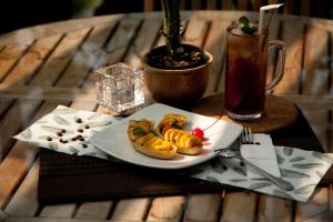 un plato de comida en una mesa con una bebida en Java Go Residence by Jiwa Jawa, en Semarang