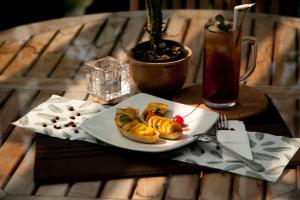 un plato de comida en una mesa con una bebida en Java Go Residence by Jiwa Jawa en Semarang