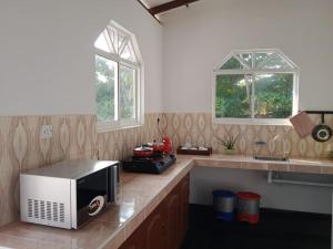 a kitchen with a microwave sitting on a counter at Gin River View Point in Gintota