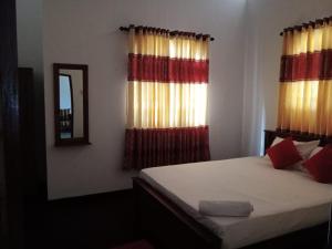 a bedroom with a bed and a mirror and curtains at Gin River View Point in Gintota