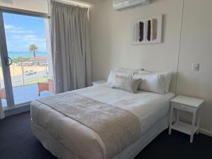 ein Hotelzimmer mit einem Bett und einem großen Fenster in der Unterkunft Frontage Apartments- 3Bedroom Central Seaview Escape in Victor Harbor + 15 Fotos