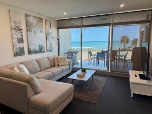 ein Wohnzimmer mit Couch und Blick aufs Meer in der Unterkunft Frontage Apartments- 3Bedroom Central Seaview Escape in Victor Harbor