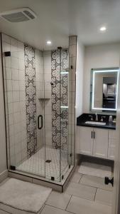a shower in a bathroom with a sink and a mirror at Primrose Inn and Suites in Chino Valley