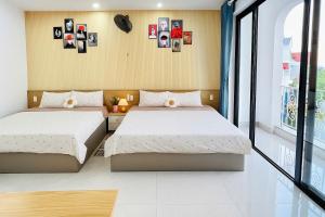 Un dormitorio con dos camas y una ventana. en Homestay phòng gần biển, TTTP - 1988 homestay, en Vung Tau