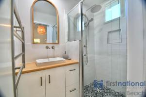 un bagno con doccia, lavandino e specchio di 1 The Esplanade a Woodgate Altre 18 foto