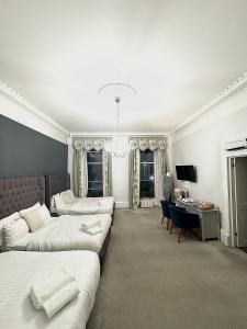 um quarto com 2 camas, uma secretária e um sofá em West Coates Mansion em Edinburgo