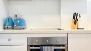 a kitchen with a stove and a blue appliance at Stunning Harbour Bridge Views Apartment in Sydney +4 photos