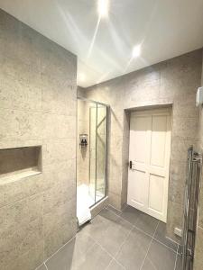 uma casa de banho com um chuveiro e uma porta branca em West Coates Mansion em Edinburgo mais 7 fotografias